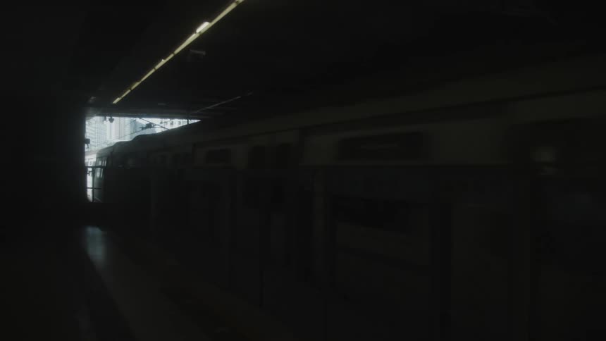 A train station at midday with a train departing from the terminal