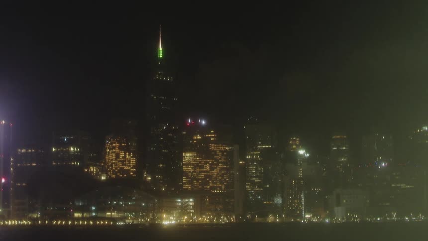 Building lights and vehicle lights shine in a waterfront city at night