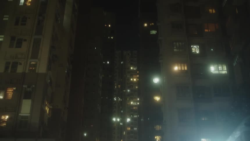 A city view at night with numerous highrise residential buildings glowing with lights from within