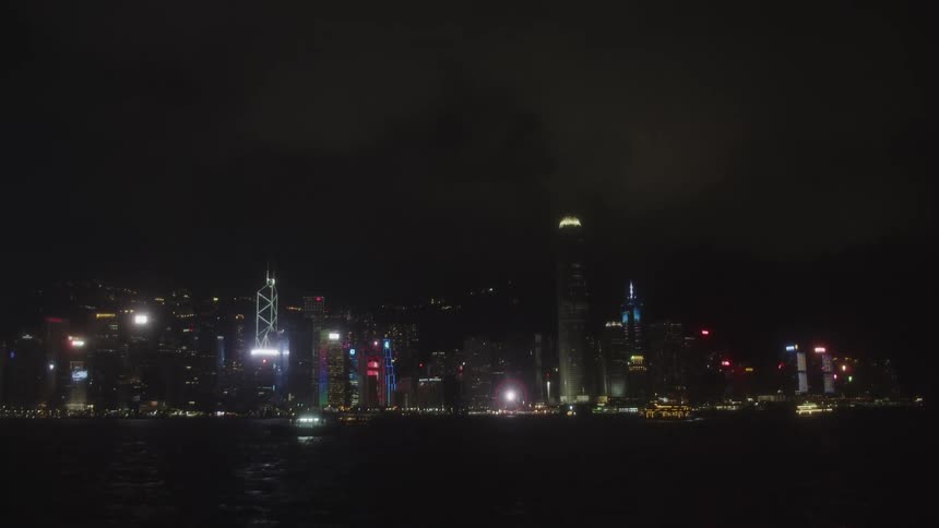 The boats pass by the large city on the shore