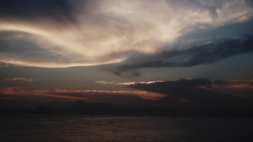 Dramatic sky displays intense tones at sunset over the sea