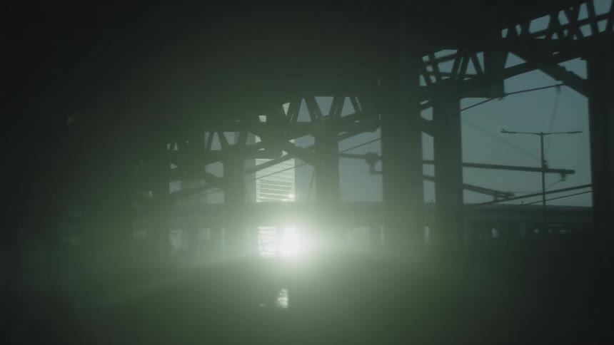 Metal structure in silhouette contrasts with the light in the background in an urban setting