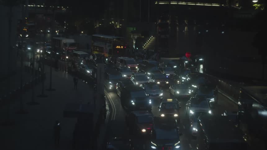 Vehicles and pedestrians navigate a busy city street with heavy traffic