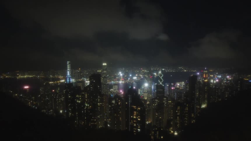 A glowing city skyline sparkles with lights under a dark night sky