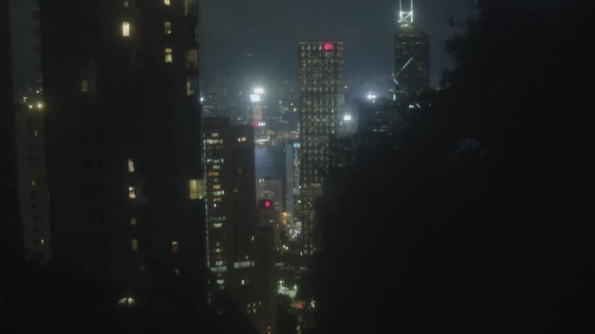 Tall buildings lit up against a dark sky in a cityscape at night