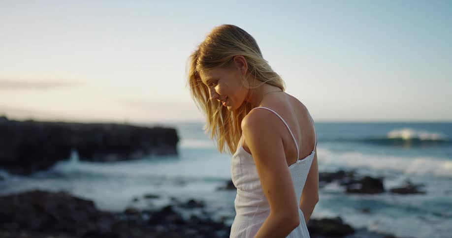 The woman is smiling on the shoreline