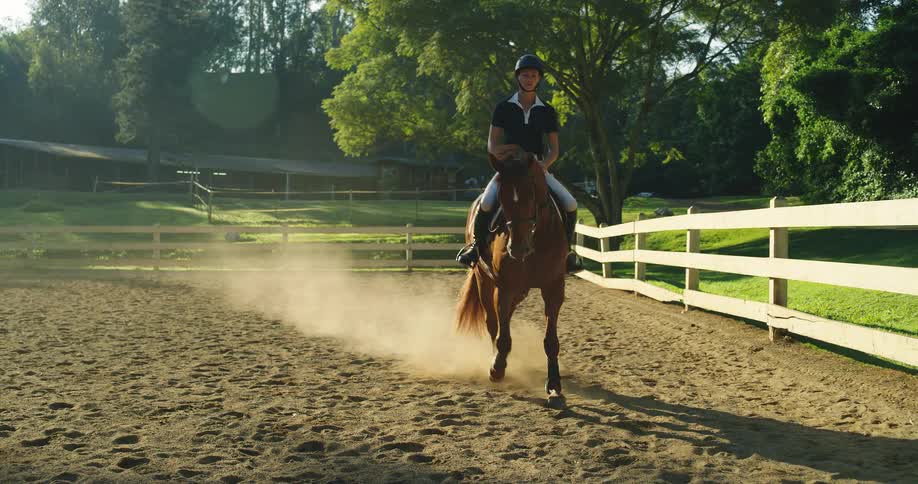 Woman rides a horse performing dressage in a corral on a summer day