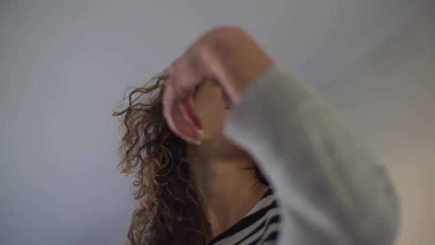 A woman moves her arm as she looks to the side