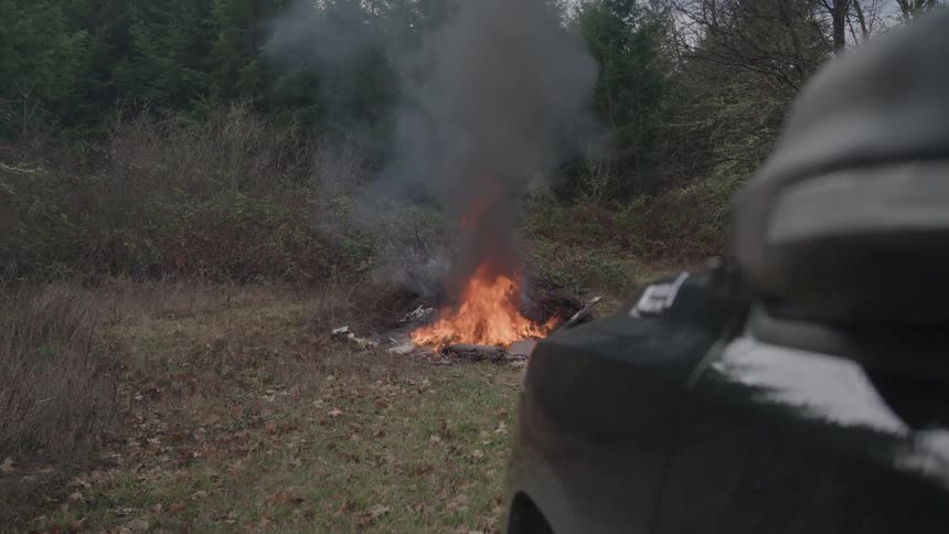 Black smoke rises from the burning debris