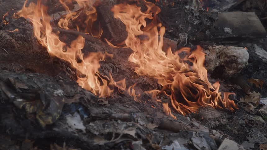 Close up of destroyed and burning items outdoors during daytime