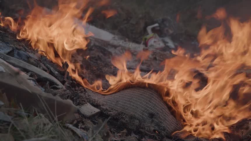 Close up of a burning items on the ground outdoors during daytime