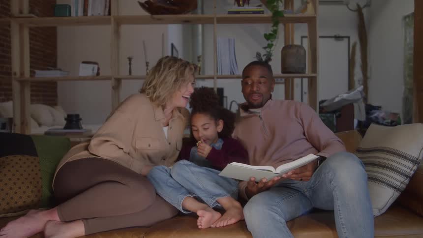 The father is reading a book to his family