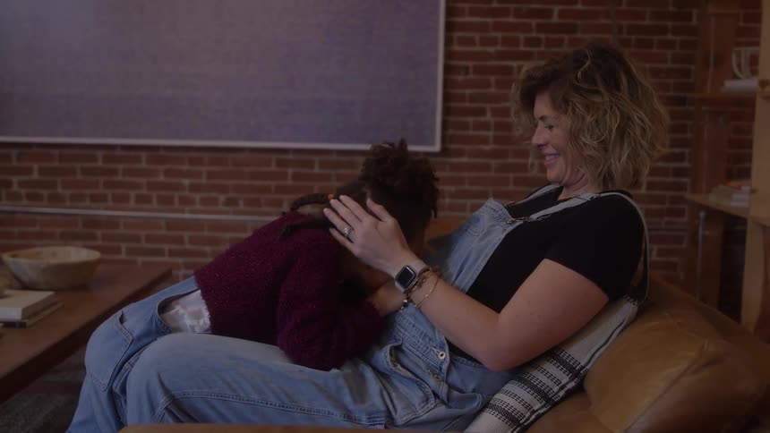 The mothers daughter taps and kisses her pregnant belly