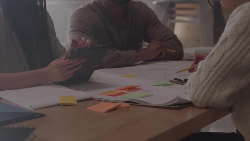 Workers talk together and look over paperwork at the desk