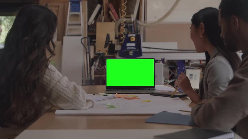 Workers watch the laptop together and talk