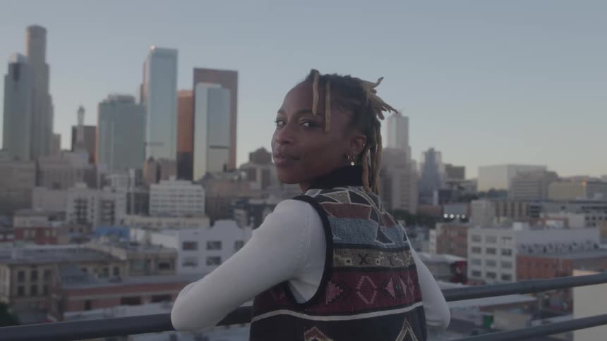 The woman leans on the balcony in the big city