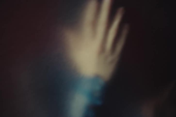 The woman slams her hands into the glass wall