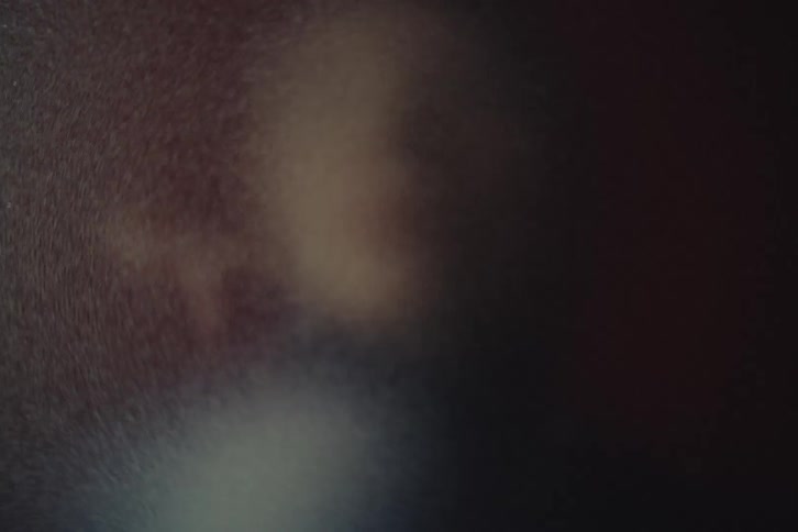 Person appears blurred in the center with a dark indistinct background