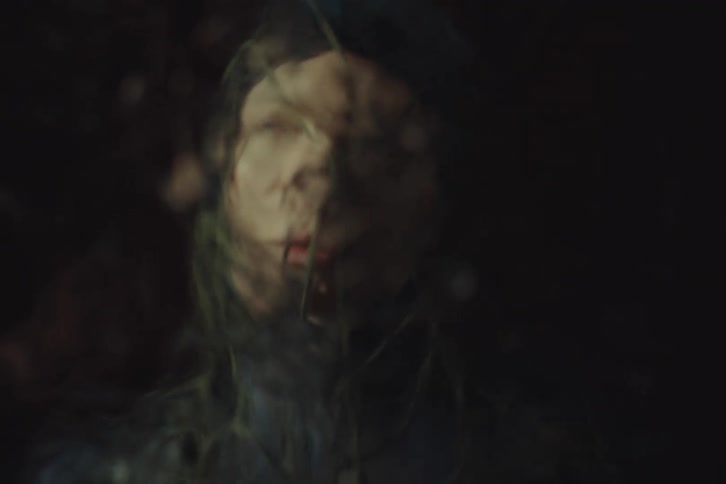 The transparent surface in front of the woman distorts her face