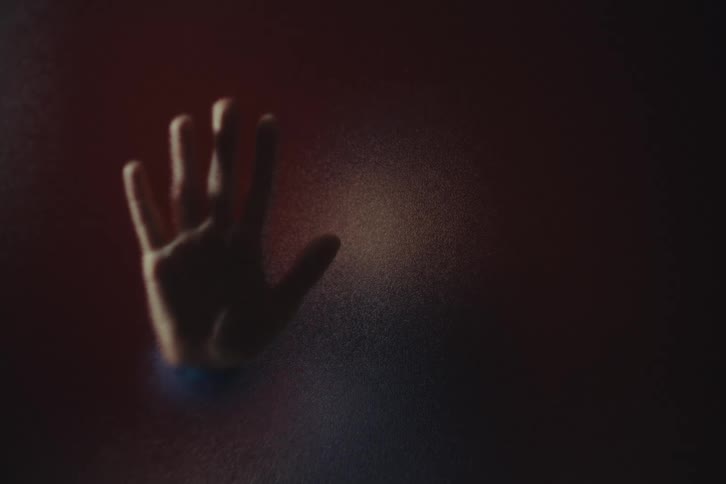 The person puts their hand on the shaded wall