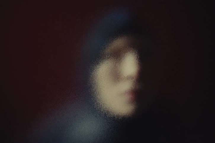 A young woman wears a beanie hat indoors