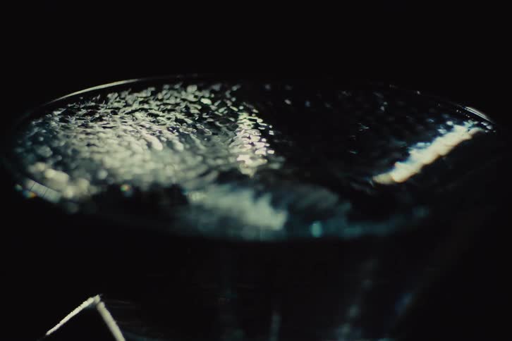 Liquid surface reflects lights in a dark and silent setting