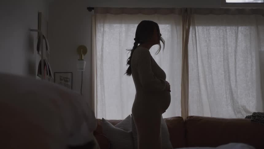 The pregnant woman is holding her belly