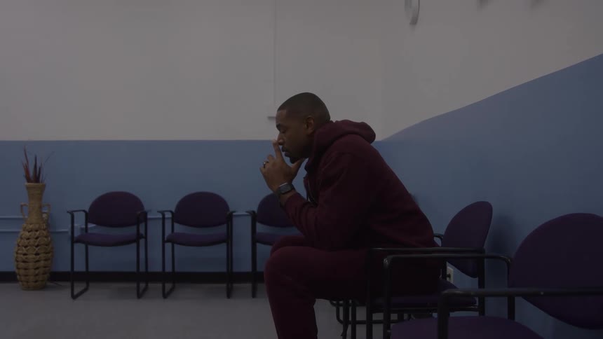Man sits in silence reflecting in an empty waiting room