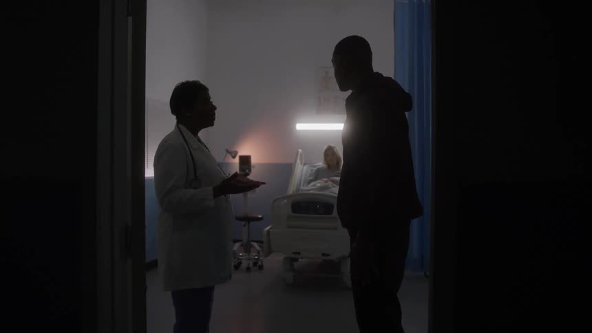 The doctor is talking with a visitor in the hospital