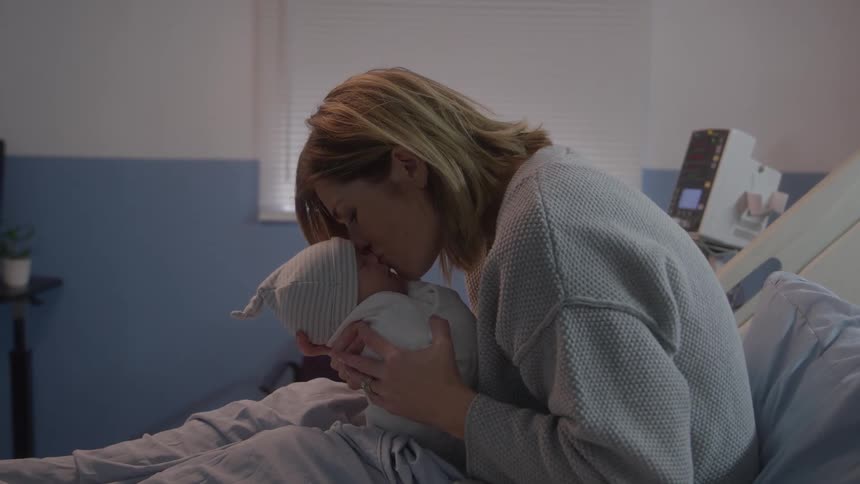 Mother gently touches the newborns face with her own face