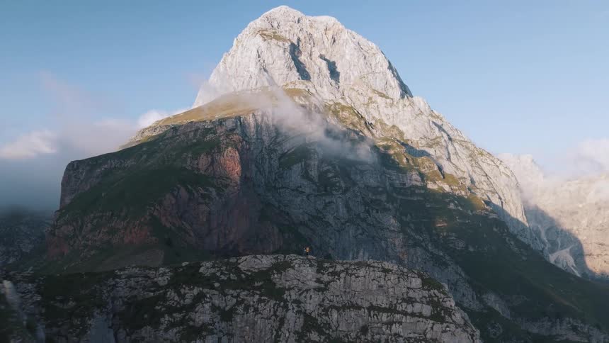 Two people are standing on the very tall mountain peak