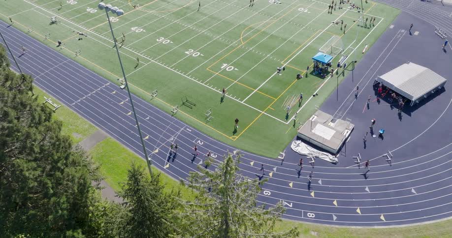 Runners pass batons to the next runner during a relay race at a track and field event