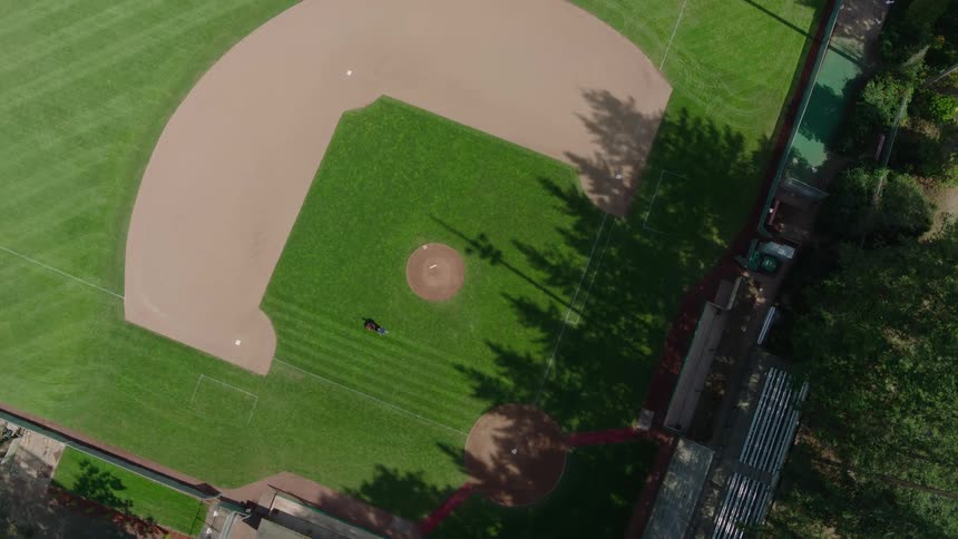 Overhead twist above a baseball field as a groundskeeper mows the infield grass