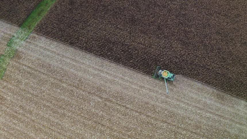 The tractor is collecting grain on the farm