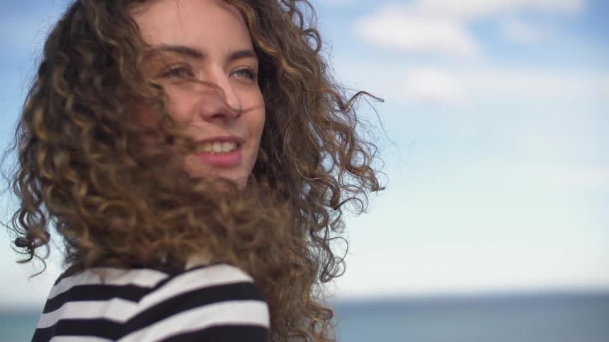 Woman smiling in front of the ocean