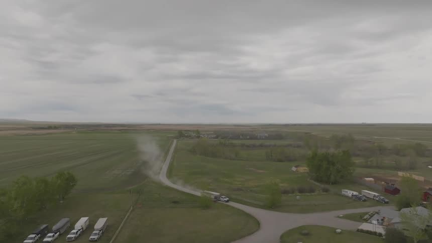 Winding road crosses a rural landscape under a cloudy sky