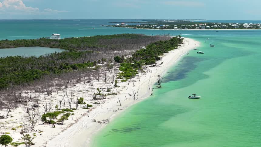 Stretch of light sand borders turquoise waters along a tropical island