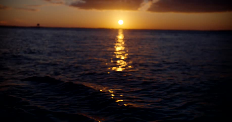 Wide view of a body of water illuminated by the sun on the dusk