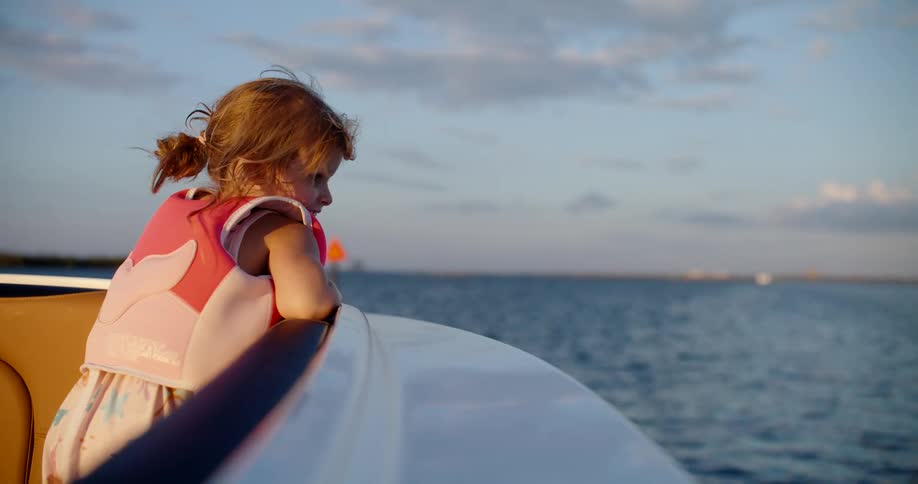 Young girl in a boat looking out to the ocean