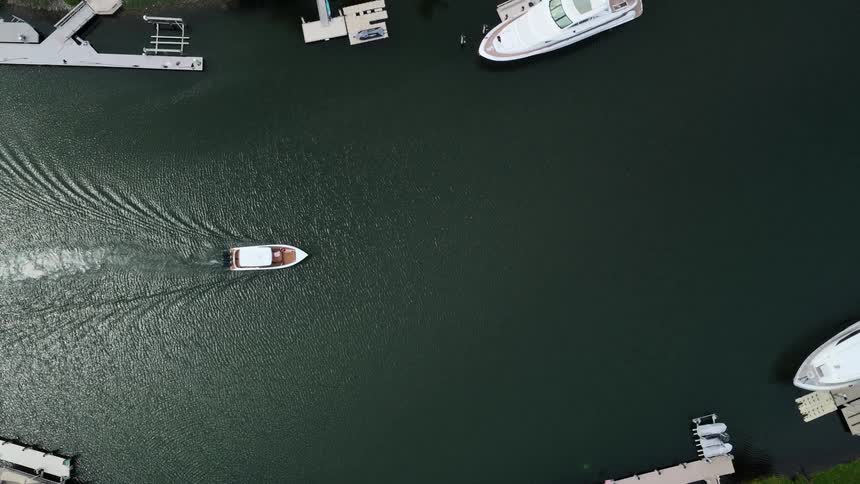 A harbor at midday with a boat passing through the water