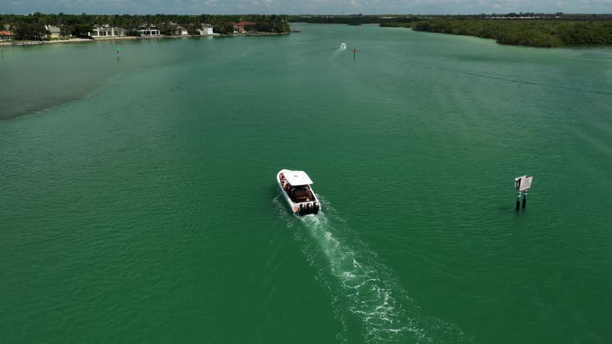 Boat sailing through green waters on a sunny day