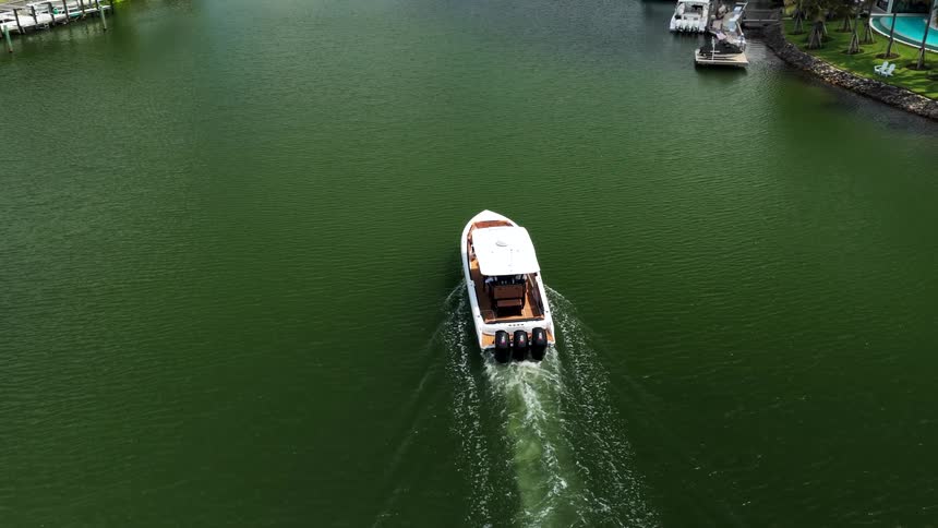 Aerial shot of a speed boat leaving a wake near a dock
