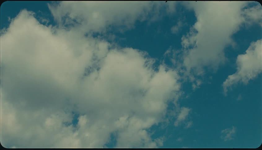 Fluffy white clouds spread across the blue sky on a clear day
