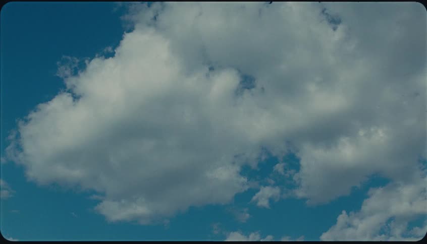White clouds drift across the blue sky on a sunny day