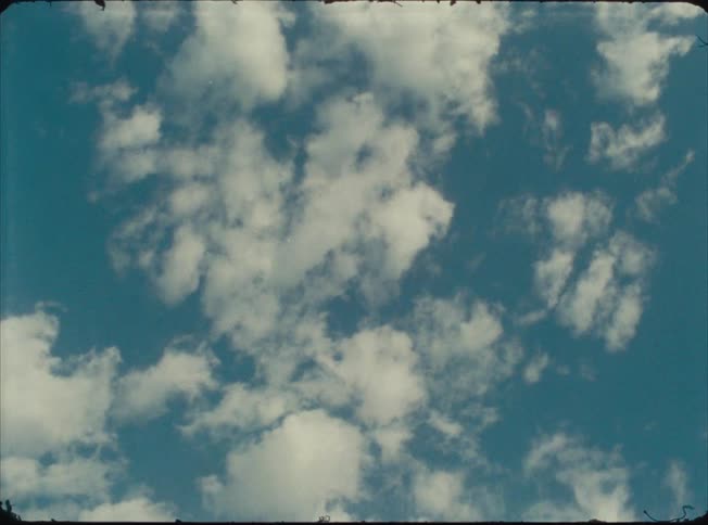 White clouds scatter across the blue sky on a clear day