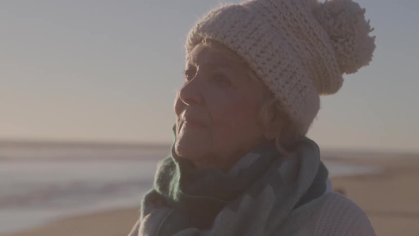 Gray hair lit by the sunlight while gazing at the horizon on the beach