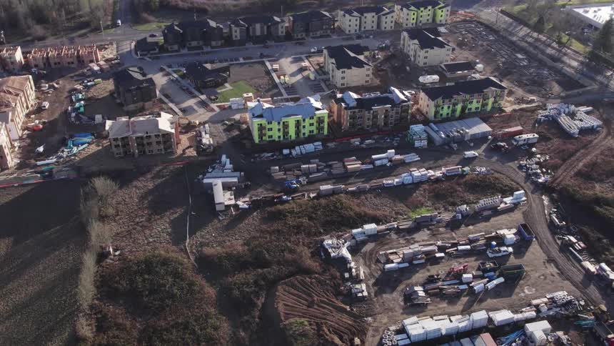 Development of an apartment complex continues between the woods and an existing housing complex