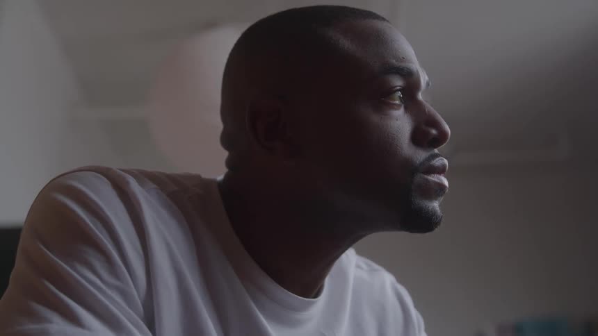 Man in a white shirt looks thoughtfully toward the light