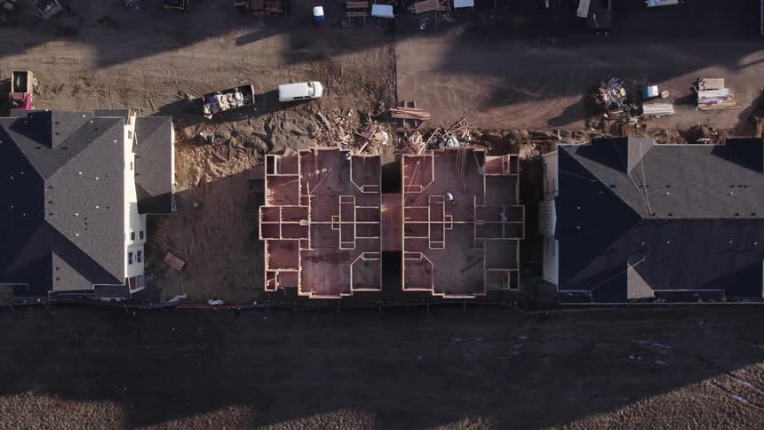 Aerial view shows a wooden structure under construction between two buildings