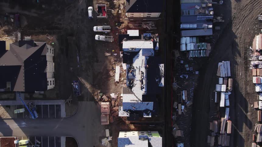 Workers operate on the construction of a building seen from above